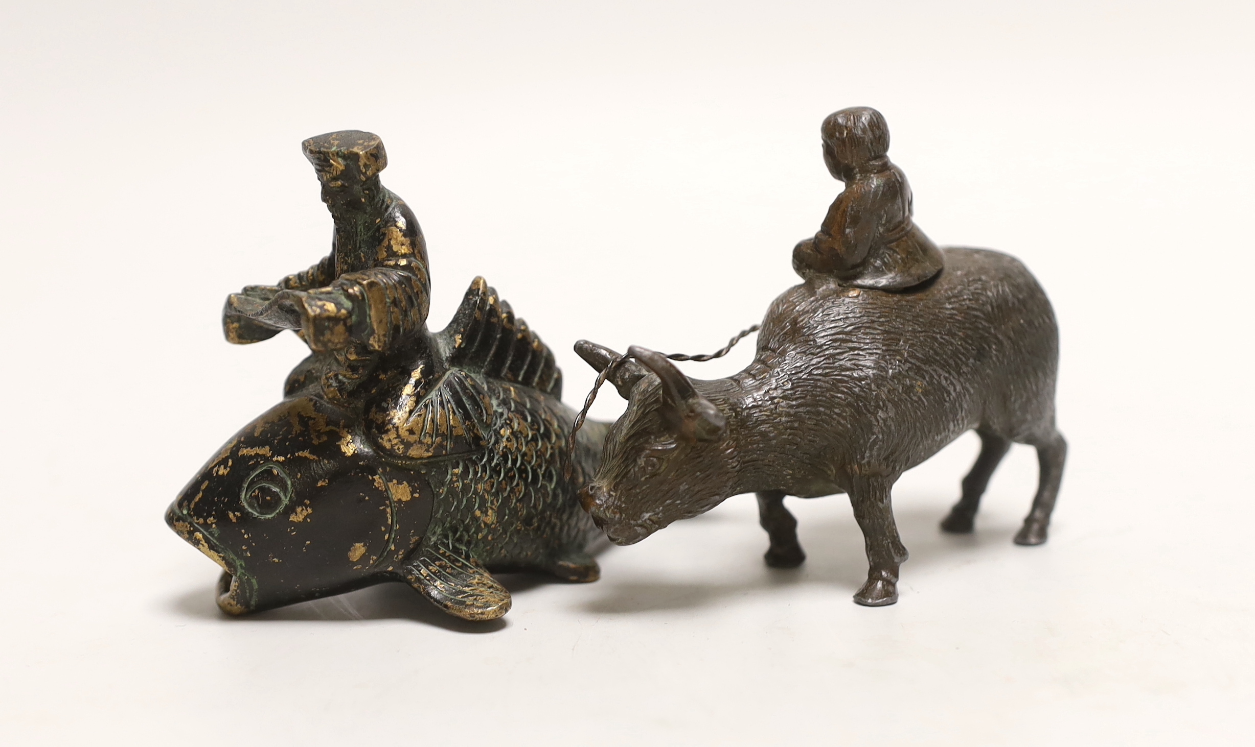 A Chinese parcel gilt metal model of a figure reading a scroll on a fish and one riding a buffalo, tallest 9cm